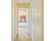 Hallway view leading to the bathroom featuring white cabinets and tile flooring at 13255 Don Loop, Spring Hill, FL 34609