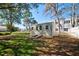 A charming storage shed with a gray exterior, surrounded by a lush lawn and a partial white picket fence at 13255 Don Loop, Spring Hill, FL 34609