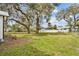 Expansive backyard with a lush green lawn shaded by mature trees at 14329 14Th St, Dade City, FL 33523