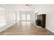 Spacious living room with wood flooring, white walls, and a brick fireplace at 14329 14Th St, Dade City, FL 33523