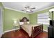 Bedroom with a wooden bed frame, ceiling fan, and natural lighting at 2580 Redwood Way, Clearwater, FL 33761