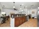 Open kitchen features dark wood cabinetry, granite counters, tile flooring, and stainless-steel appliances at 2580 Redwood Way, Clearwater, FL 33761
