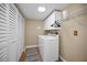 Bright laundry room features a washer, dryer, storage cabinets and a large closet with folding doors at 2580 Redwood Way, Clearwater, FL 33761