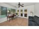 Bright sun room with a desk, black sofa, and outdoor views through sliding glass doors at 2580 Redwood Way, Clearwater, FL 33761