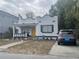 Charming white stucco home with a yellow front door and a cozy front porch at 2613 E 23Rd Ave, Tampa, FL 33605