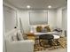 Bright living room features a white sofa, chair, contemporary rug, neutral tones, and natural light from the windows at 2613 E 23Rd Ave, Tampa, FL 33605