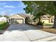 Charming single-story home featuring a two-car garage, neutral stucco, and mature trees in a landscaped yard at 305 Taxter Run Ln, Valrico, FL 33594