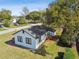 Angled aerial view of a bright, charming single-story home surrounded by verdant greenery at 38638 2Nd Ave, Zephyrhills, FL 33542