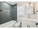 Stylish bathroom features gray tiled walls, modern fixtures, and a bright vanity with a decorative mirror at 38638 2Nd Ave, Zephyrhills, FL 33542
