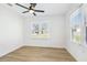 Bright bedroom features hardwood floors, white walls, and natural light from two windows at 38638 2Nd Ave, Zephyrhills, FL 33542