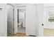 Hallway view of tiled bathroom and bright bedroom with hardwood floors and modern decor at 38638 2Nd Ave, Zephyrhills, FL 33542