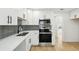 Modern kitchen with white cabinets, stainless steel appliances, and stylish gray backsplash tiles at 38638 2Nd Ave, Zephyrhills, FL 33542