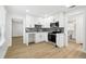 Bright kitchen boasts white cabinetry, stainless steel appliances, and sleek wood flooring at 38638 2Nd Ave, Zephyrhills, FL 33542