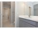 Bathroom features a gray vanity with a white countertop, large mirror, and doorway view of adjacent toilet and shower at 4549 Chinkapin Dr, Sarasota, FL 34232