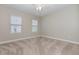 A clean, carpeted bedroom features two windows with blinds and neutral-toned walls and a ceiling fan at 4549 Chinkapin Dr, Sarasota, FL 34232