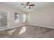 Bedroom with carpet, ceiling fan, two windows, and a door to the outside at 4549 Chinkapin Dr, Sarasota, FL 34232