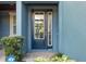 Elegant front door featuring glass panels and sidelights, complemented by lush greenery at 4549 Chinkapin Dr, Sarasota, FL 34232