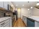 Modern kitchen features stainless appliances, gray cabinets, stone countertops, and a center island with sink and dishwasher at 4549 Chinkapin Dr, Sarasota, FL 34232