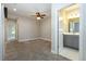 Carpeted primary bedroom with ceiling fan, en-suite bathroom featuring gray vanity and access to hallway at 4549 Chinkapin Dr, Sarasota, FL 34232