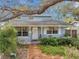 Charming light blue two-story home featuring a covered porch and mature landscaping at 5036 18Th N St, St Petersburg, FL 33714