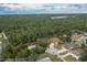 Aerial view showcasing the neighborhood with mature trees, homes and a lake in the distance at 5443 Ott Ct, Spring Hill, FL 34608