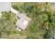 An aerial view of a home with a well-maintained lawn, mature trees, and a covered entrance at 5443 Ott Ct, Spring Hill, FL 34608