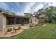 A lovely backyard featuring a screened lanai, lush garden bed, and a charming decorative fountain at 5443 Ott Ct, Spring Hill, FL 34608