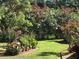 Lush backyard featuring vibrant flower bushes and meticulously manicured lawn offering a serene outdoor space at 5443 Ott Ct, Spring Hill, FL 34608