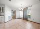 Bright dining area with tile floors, a decorative chandelier, and a large window offering outdoor views at 5443 Ott Ct, Spring Hill, FL 34608