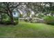 Landscaped front yard showcasing mature trees and well-maintained lawn for great curb appeal and character at 5443 Ott Ct, Spring Hill, FL 34608