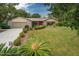 Charming home with a well-manicured front lawn, a two car garage, and a welcoming red front door at 5443 Ott Ct, Spring Hill, FL 34608