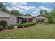 Charming home featuring manicured landscaping with mulch, lush green lawn and attractive stone accent wall at 5443 Ott Ct, Spring Hill, FL 34608