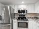 Updated kitchen featuring stainless steel appliances, white cabinetry, and lovely granite countertops at 5443 Ott Ct, Spring Hill, FL 34608