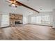 Large living room featuring wood flooring, a stone fireplace, vaulted ceilings, and bright, airy windows at 5443 Ott Ct, Spring Hill, FL 34608