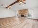 Bright living room with wood floors, stone fireplace, ceiling fans, and large windows with sheer curtains at 5443 Ott Ct, Spring Hill, FL 34608