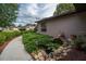 Peaceful side yard view with manicured greenery, stone accents, a charming water feature, and a paved walkway at 5443 Ott Ct, Spring Hill, FL 34608