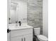 Modern half bathroom features a white vanity with a rectangular mirror and stylish horizontal stacked tiling at 6213 64Th N Way, Pinellas Park, FL 33781