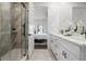 Bathroom featuring double vanity, modern fixtures, and a glass-enclosed shower with walk-in closet at 6213 64Th N Way, Pinellas Park, FL 33781