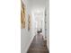 Hallway with hardwood floors, white walls, modern art, and access to the bedrooms at 6213 64Th N Way, Pinellas Park, FL 33781