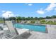 The sparkling community pool is enhanced by lounge chairs, shade umbrellas, and well-maintained landscaping at 6213 64Th N Way, Pinellas Park, FL 33781