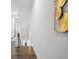 Hallway with modern art, stairs leading to an upstairs, and hardwood floors at 6213 64Th N Way, Pinellas Park, FL 33781