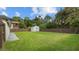 Large backyard featuring green grass, a wooden fence, and a shed at 6291 63Rd N St, Pinellas Park, FL 33781