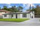 Inviting single-story home featuring a green lawn, dark trim, and solar panels at 6291 63Rd N St, Pinellas Park, FL 33781
