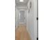 Hallway with light wood floors and decorative wall art, showcasing the home's interior design at 6291 63Rd N St, Pinellas Park, FL 33781