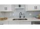 Close up on a stainless steel kitchen sink with modern faucet and stylish grey tile backsplash at 6291 63Rd N St, Pinellas Park, FL 33781