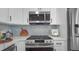 Modern kitchen features stainless steel microwave and stove, sleek countertops and tile backsplash at 6291 63Rd N St, Pinellas Park, FL 33781