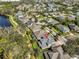An aerial view showcases the home's well-maintained lawn and mature trees, near a tranquil lake at 6640 Park Strand Dr, Apollo Beach, FL 33572