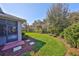 Beautifully landscaped backyard with lush green lawn, mature trees, and privacy hedges at 6640 Park Strand Dr, Apollo Beach, FL 33572