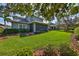 Expansive backyard featuring manicured lawn, mature trees, and a covered patio at 6640 Park Strand Dr, Apollo Beach, FL 33572