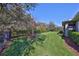 Well-maintained backyard with green grass, mature trees, and a fenced perimeter at 6640 Park Strand Dr, Apollo Beach, FL 33572